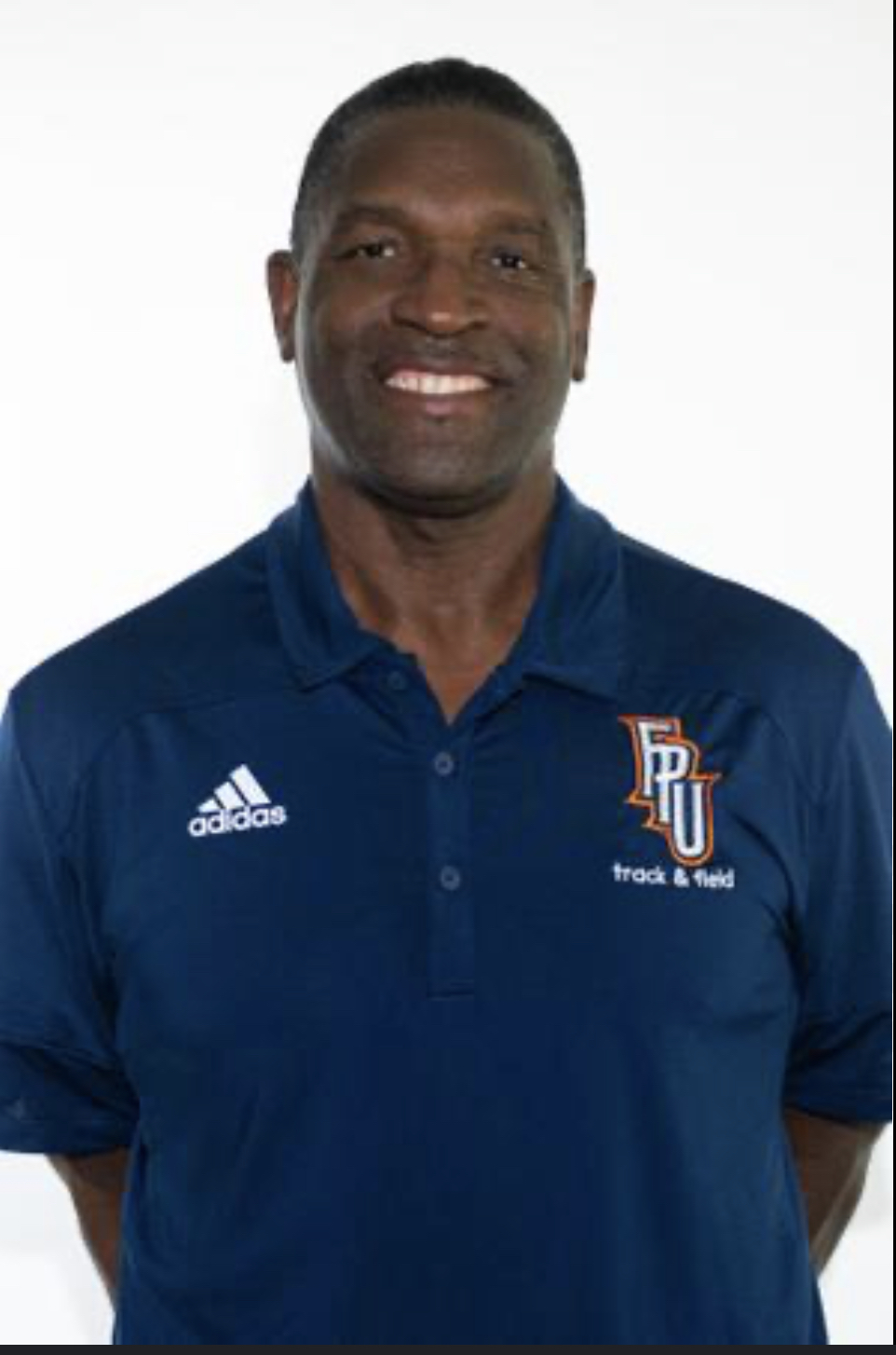 Robert Foster wearing a blue shirt with the Adidas logo and an FPU Track and Field logo. He has a wife smile on his face.