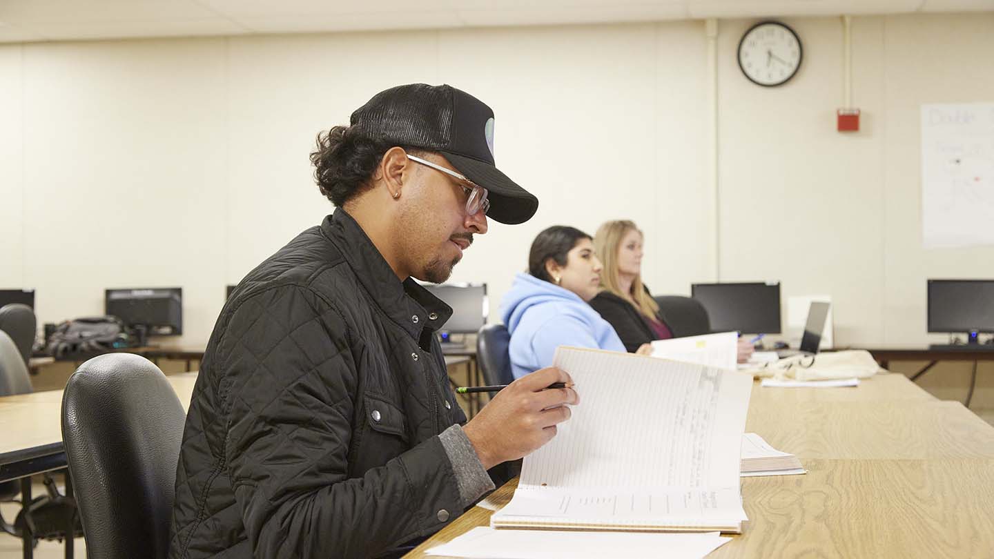 A student flipping through a notebook during class