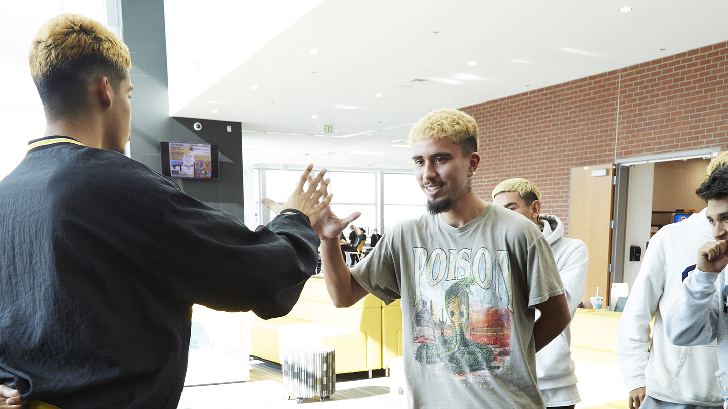 Men's soccer team members hang out in the student lounge.