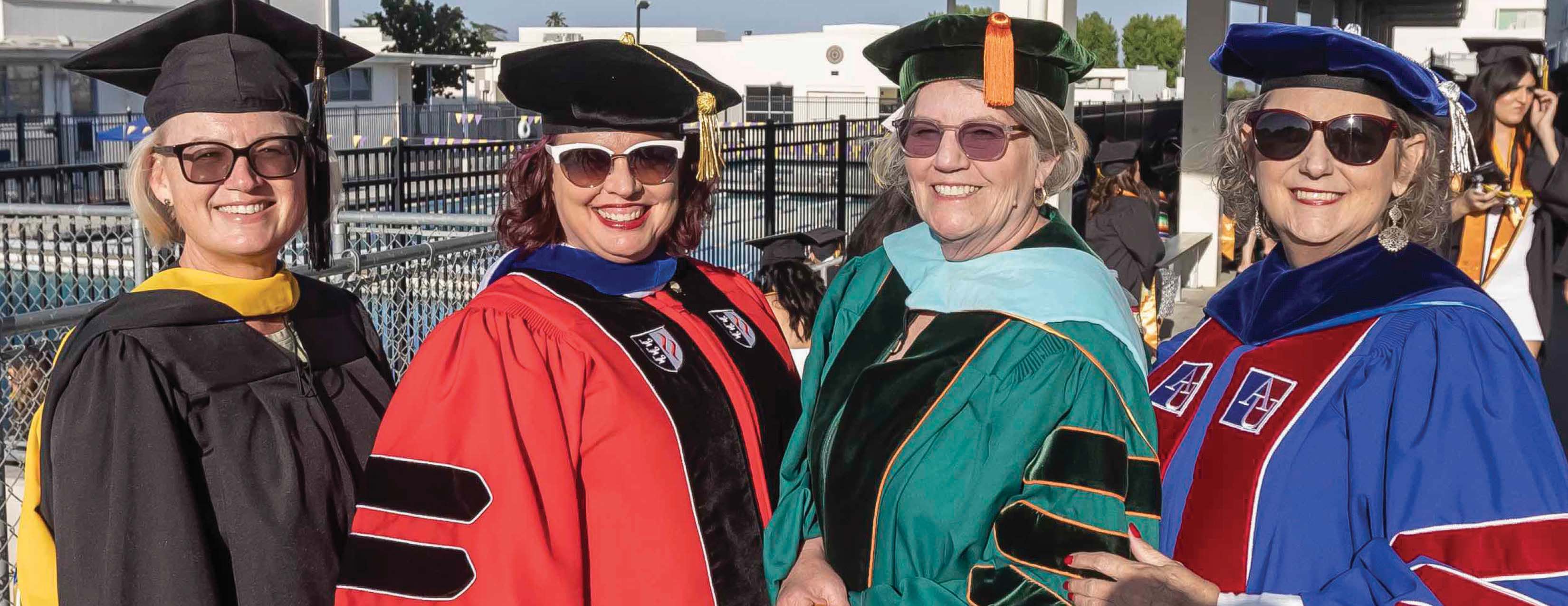 Four Professors line up for a photo before Commencement