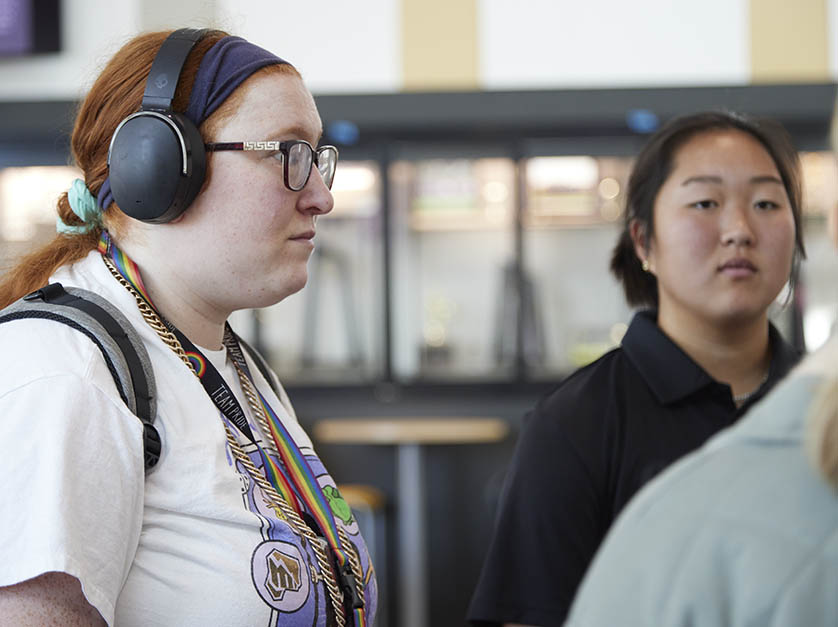 Two female students focus on their Faculty Advisor's comments in Student Center lounge area.