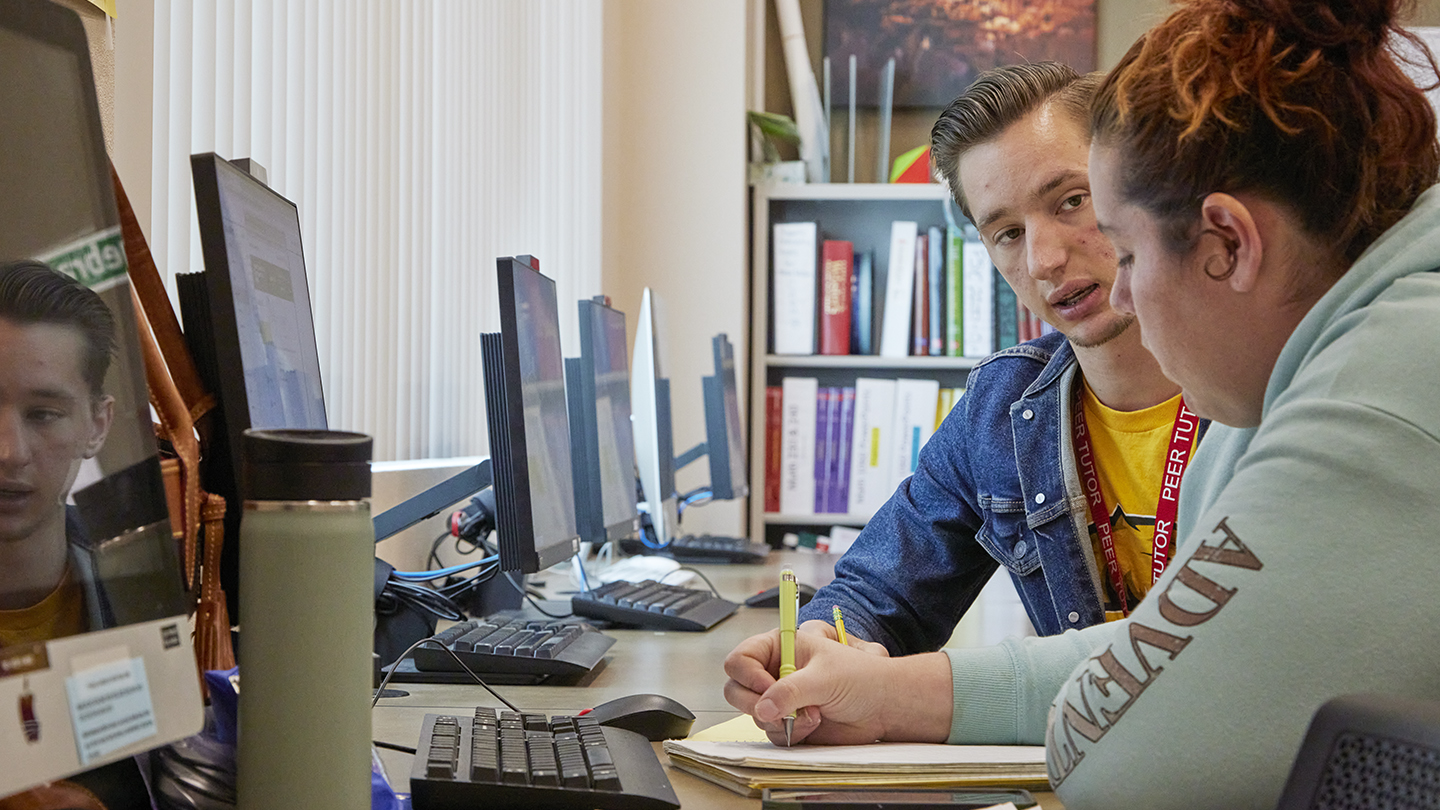 A peer tutor works one-on-one with a fellow student in the Math Lab.