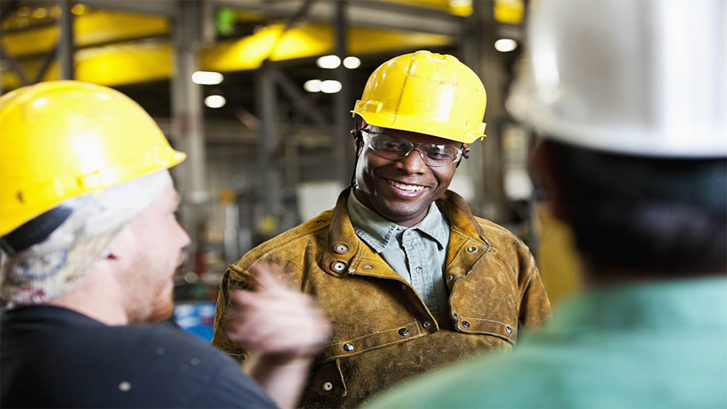 Men in hard hats chat at a construction site