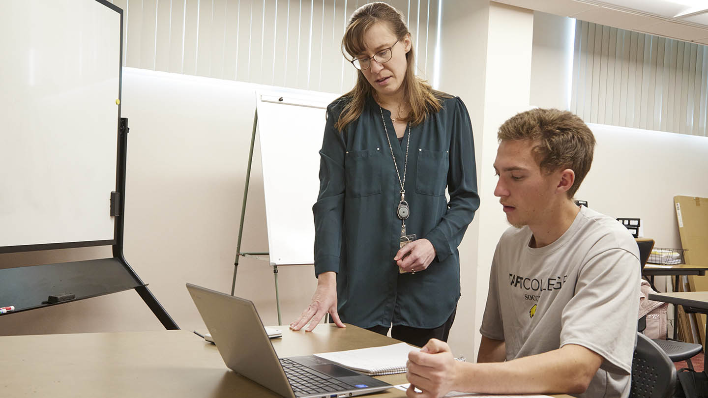 A female professor works one-on-one with a male student in the Calc Lab.