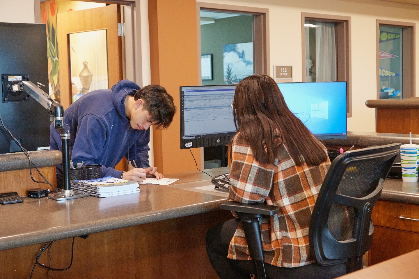Student fills out paperwork at Financial Aid Desk